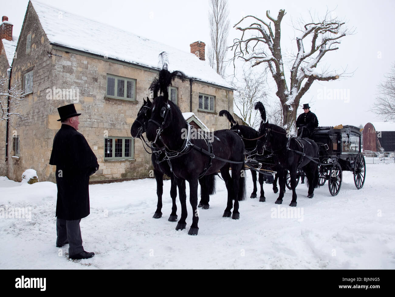 Traditionelle alte altmodische Pferdekutsche Beerdigung Schlitten im Schnee mit vier Pferden bereit für Gottesdienst verlassen Stockfoto