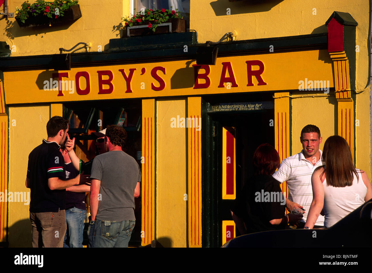 Irland, County Mayo, Westport, Leute, die sich vor Tobys Bar unterhalten Stockfoto