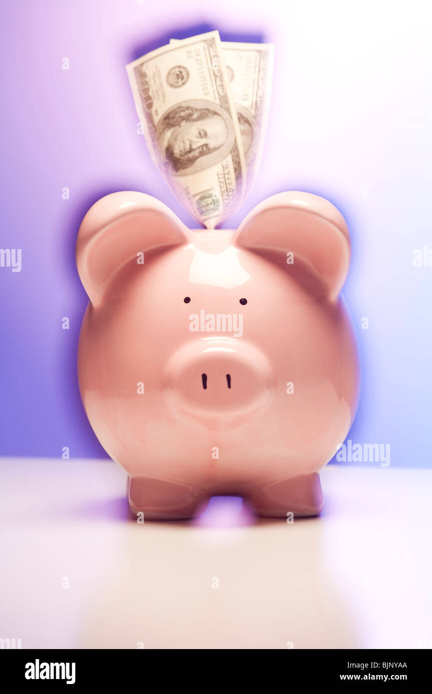 Rosa Sparschwein mit Dollarnoten Stockfoto Rosa Sparschwein mit Dollarnoten Stockfoto