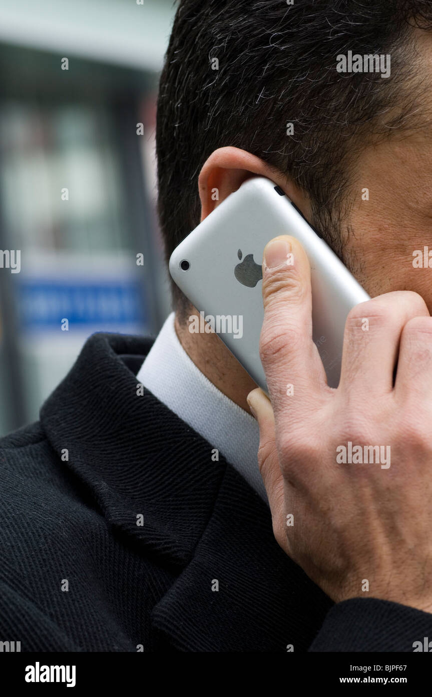 Business-Mann sprechen auf einem Iphone mobile außerhalb eines Bürogebäudes Berlin Deutschland Stockfoto