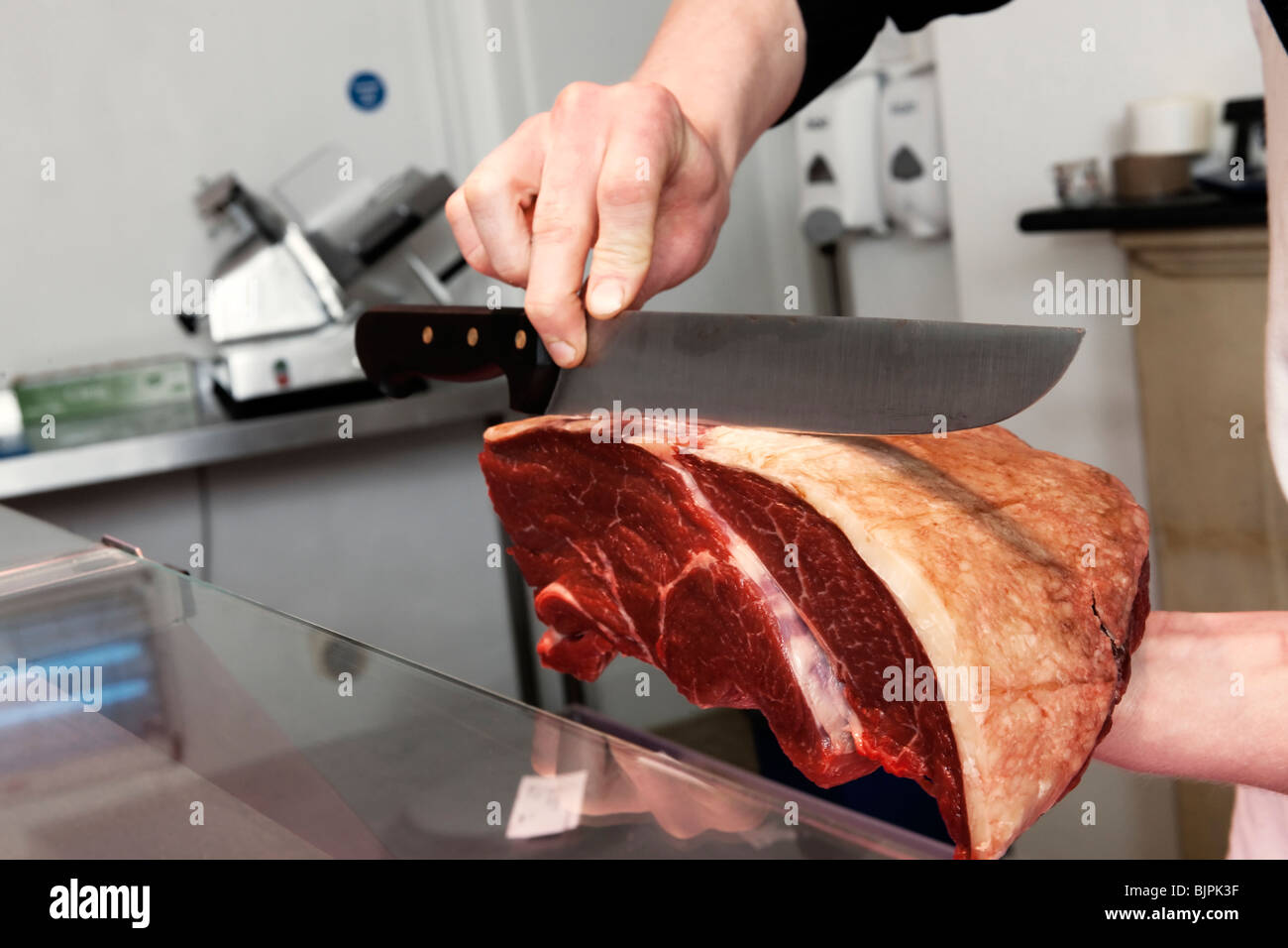 Metzger zeigt auf Gelenk des Rindfleisches Schnitt Stockfoto