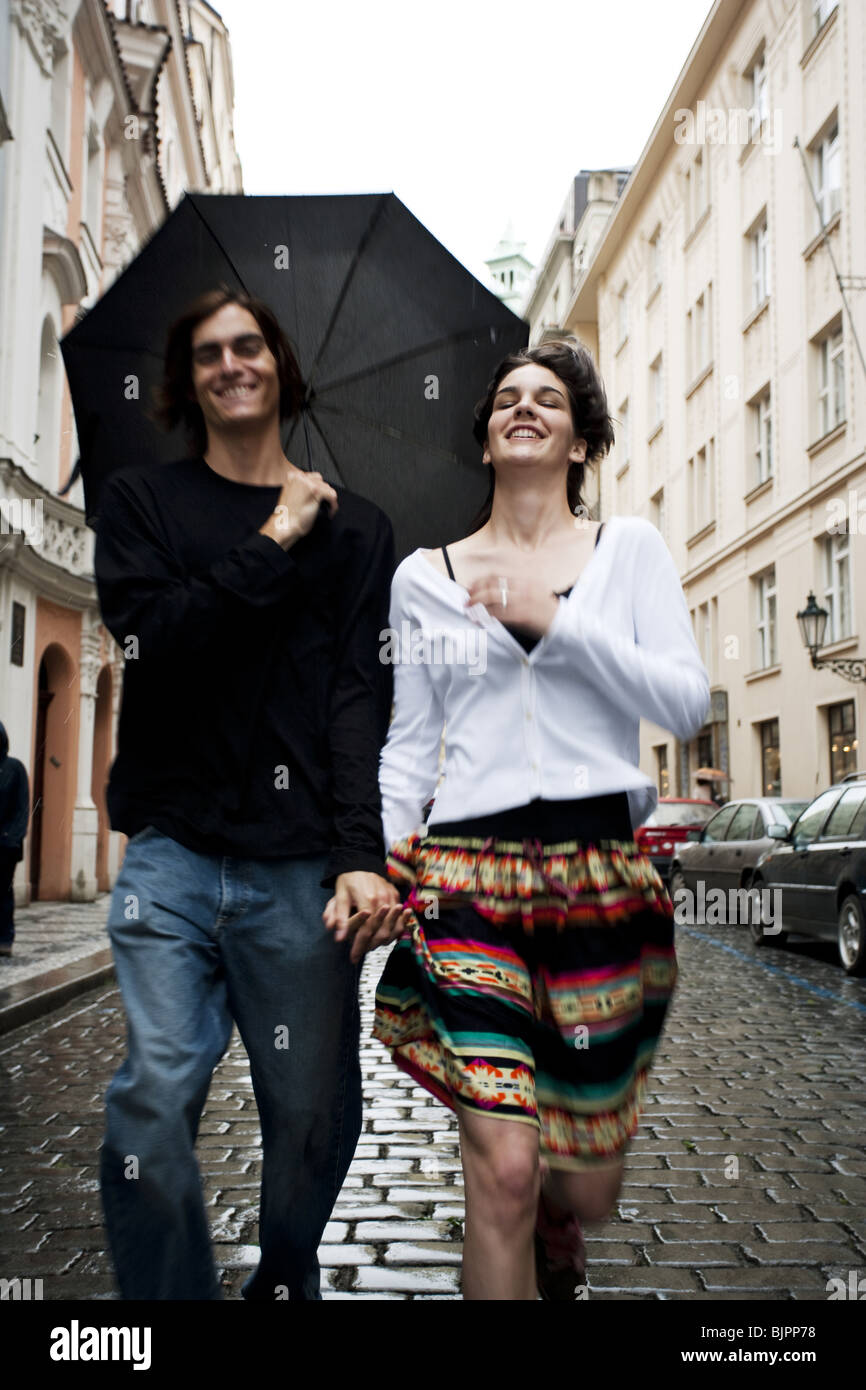 Paar im Regen Hand in Hand Stockfoto
