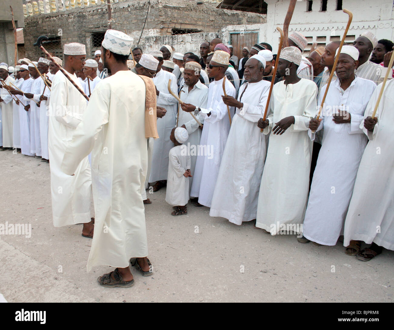 Männer führen den Stocktanz Kirumbizi während Maulidi außerhalb von Riyadha Moschee Lamu, Kenia Stockfoto