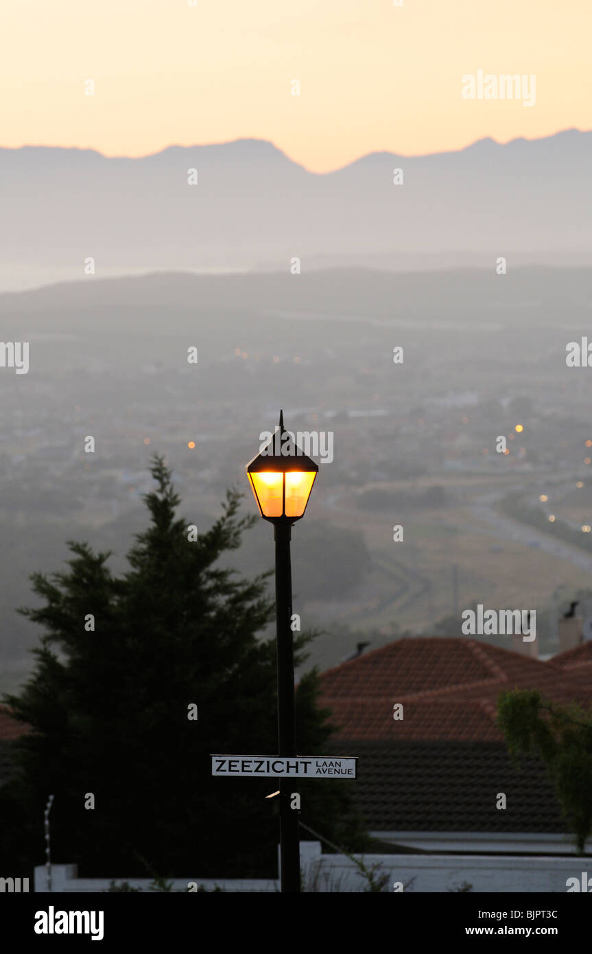 Straßenlaterne leuchtet in der Dämmerung auf einer Straße in Somerset West western Cape / Südafrika Stockfoto