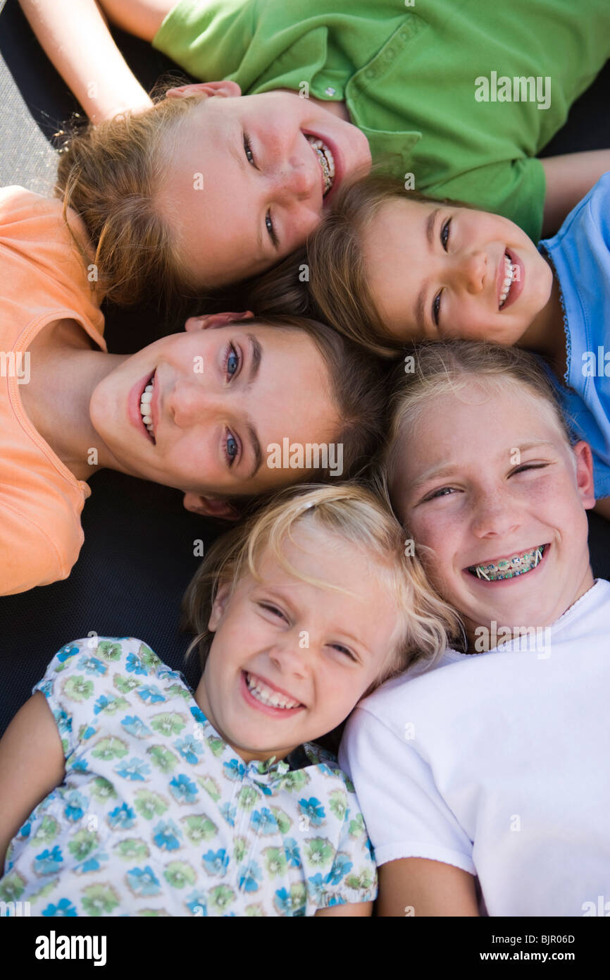 Gruppe von Freundinnen liegen auf dem Rücken lächelnd Stockfoto
