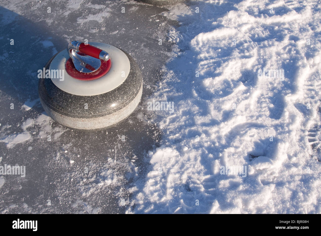 Curling-Stein auf Schnee bedeckt zugefrorenen See Stockfoto