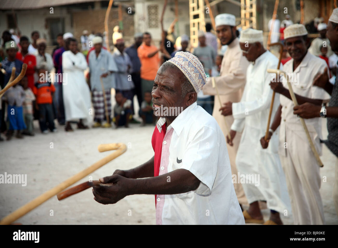 Männer führen den Stocktanz Kirumbizi während Maulidi außerhalb von Riyadha Moschee Lamu, Kenia Stockfoto