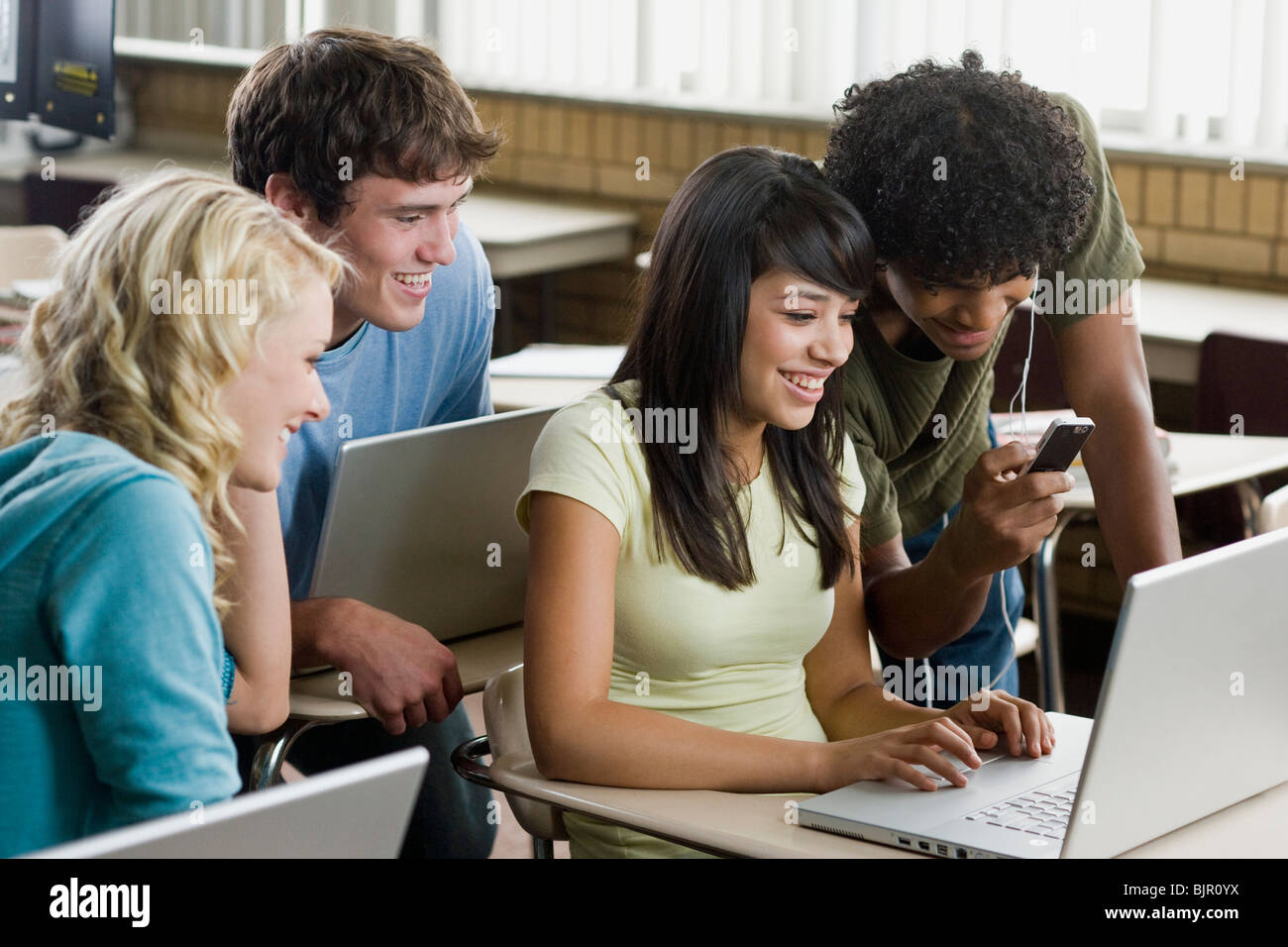 Vier Studenten drängten sich um einen Notebook-Computer. Stockfoto