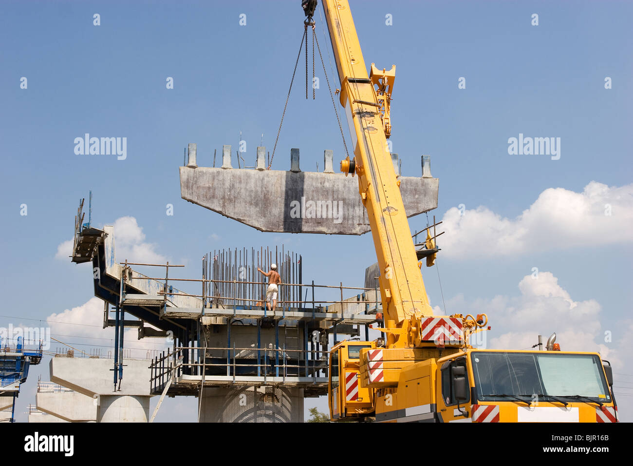 Kran heben einen Metallrahmen auf Säule zu setzen Stockfoto