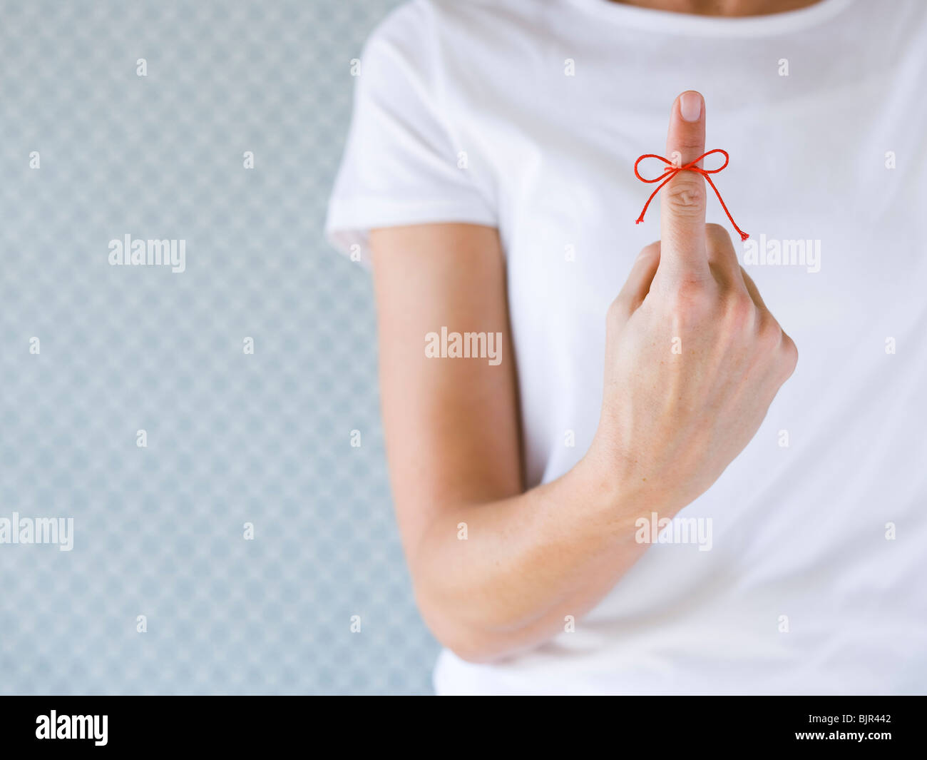 Frau mit einer roten Schnur an ihrem Finger. Stockfoto