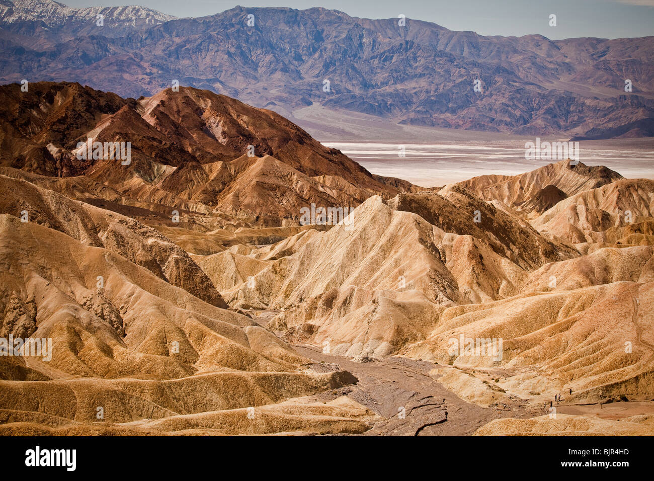 Wanderer in den Badlands am Zabriskie Point mit Blick auf Golden Canyon in Death Valley Nationalpark, Kalifornien, USA. Stockfoto