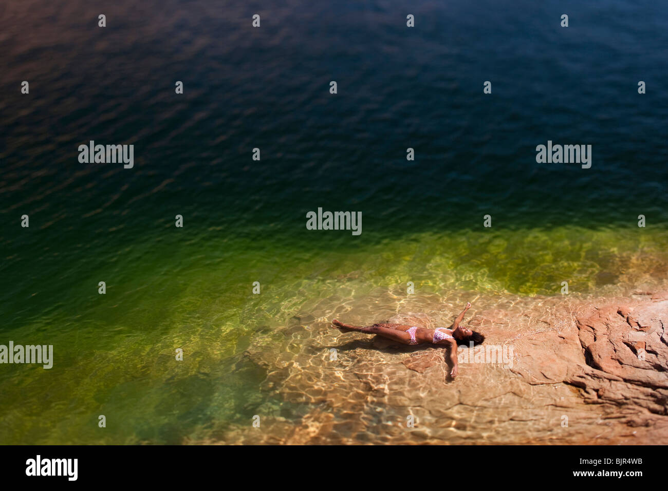 Frau im Wasser auf Rücken liegend Stockfoto