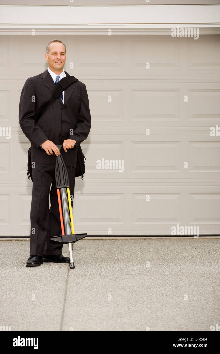 Zwei Geschäftsleute mit einem auf einem Pogo stick Stockfoto