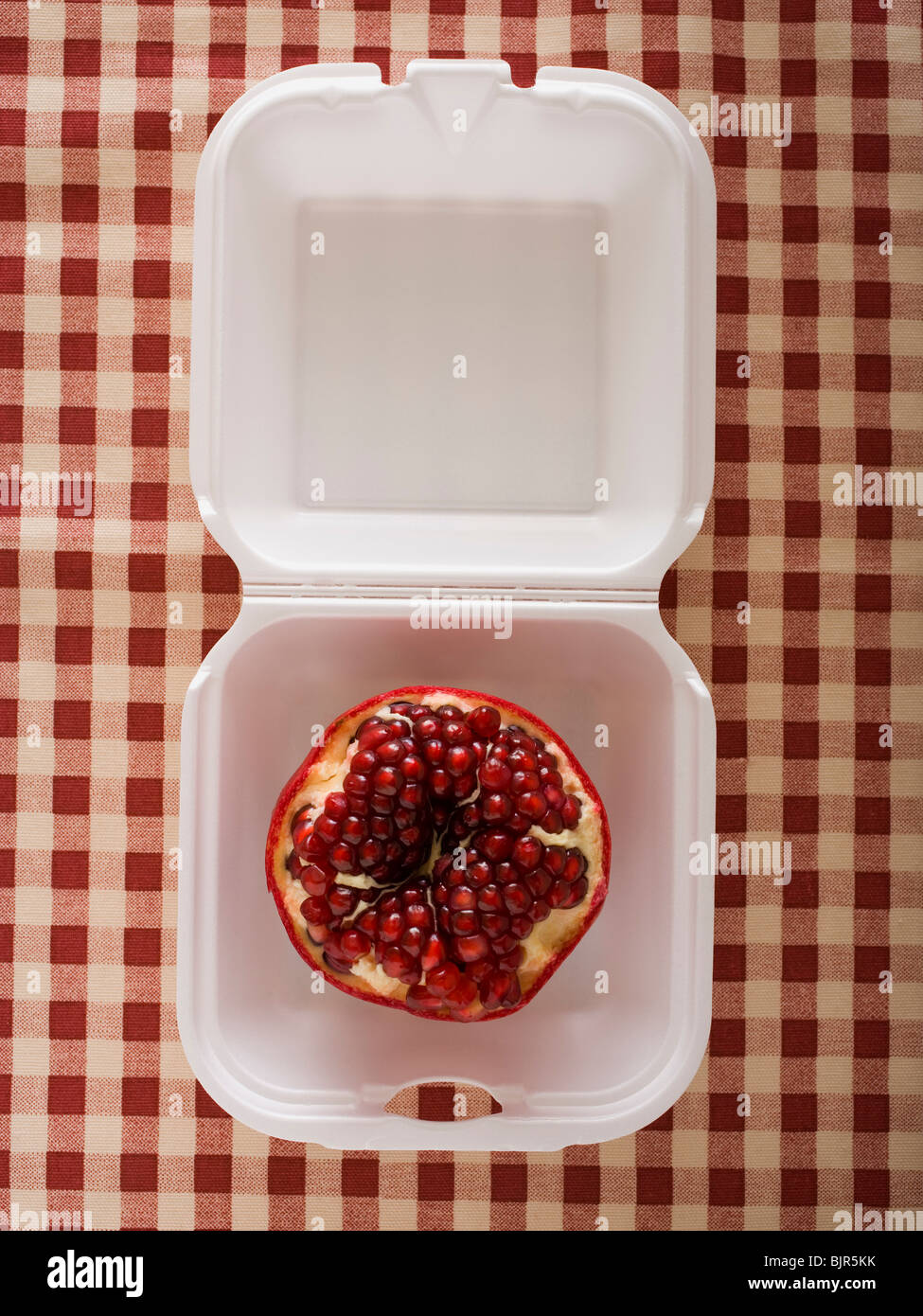 Granatapfel in einem Fast-Food-container Stockfoto