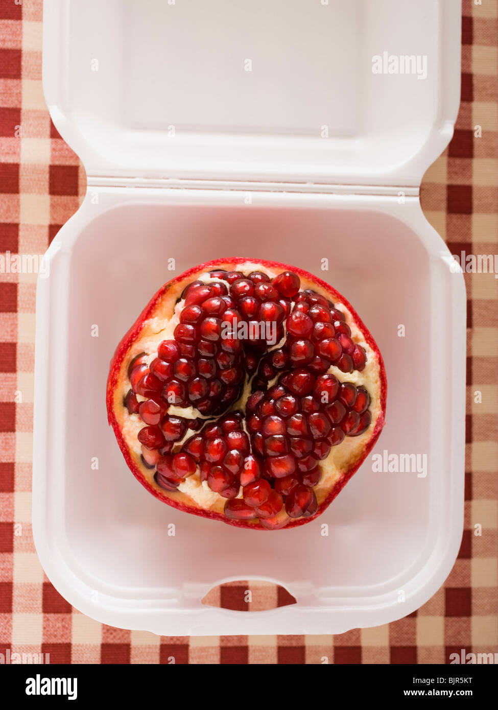 Granatapfel in einem Fast-Food-container Stockfoto