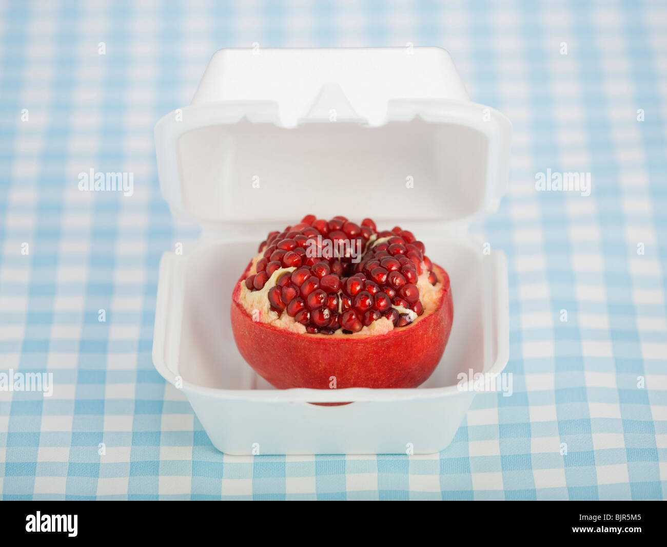 Granatapfel in einem Fast-Food-container Stockfoto