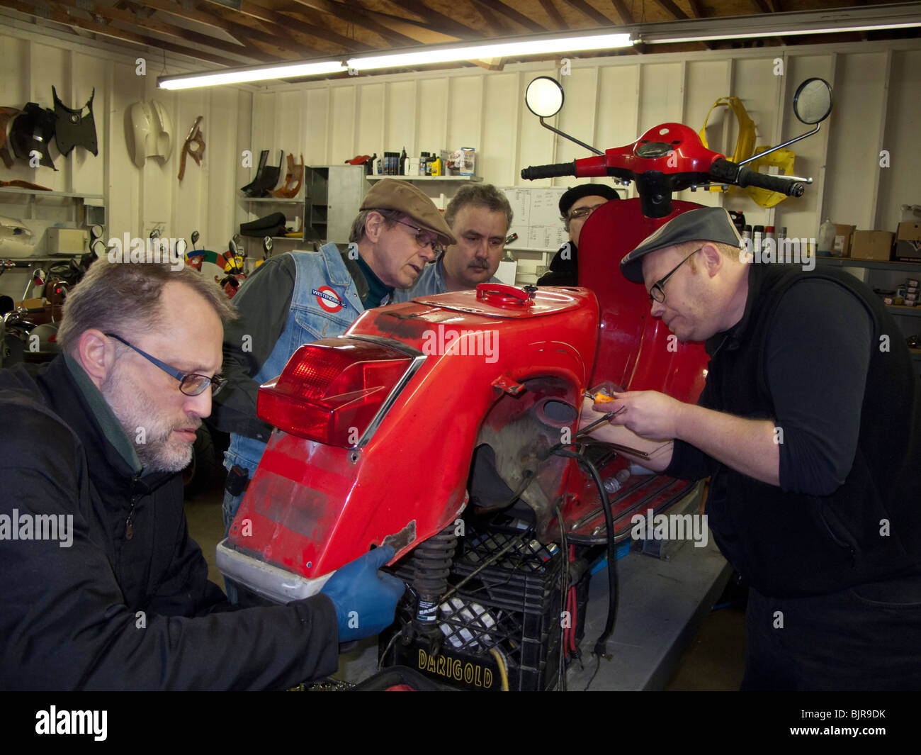 Roller-Club-Mitglieder arbeiten an Vespa P200 Reparatur und Restauration im shop Stockfoto