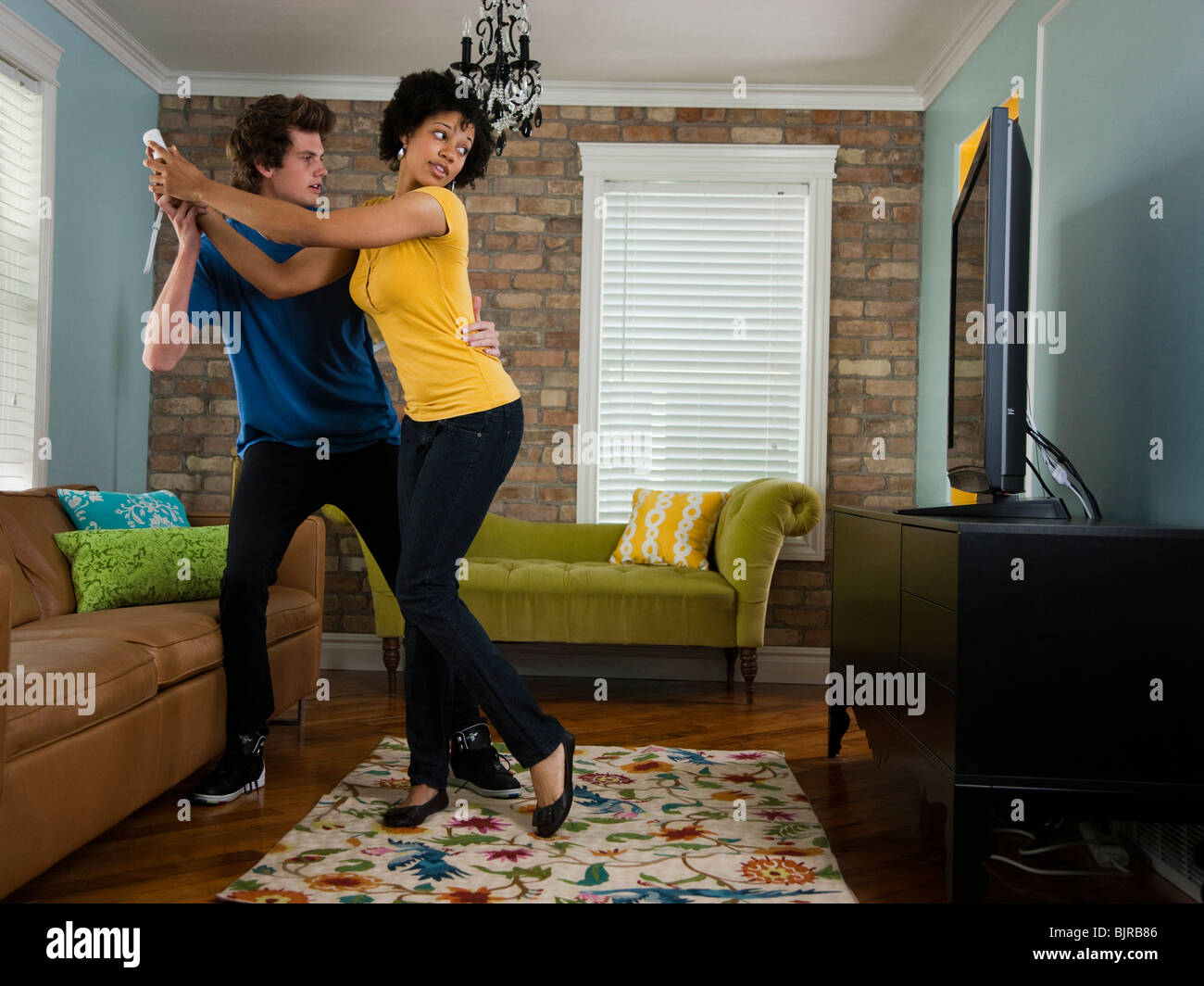 USA, Utah, Provo, junges Paar mit Fernbedienung im Wohnzimmer Stockfoto