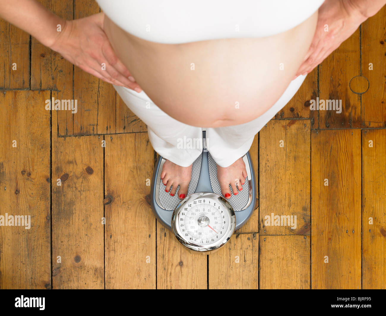 Schwangere Frau auf Skalen Stockfoto