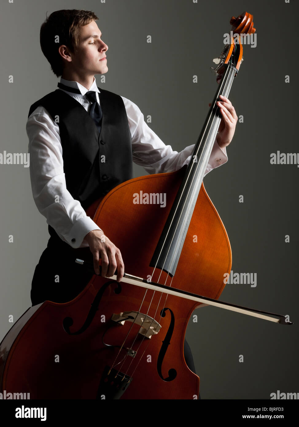 Junger Mann spielt Kontrabass, Studio gedreht Stockfoto