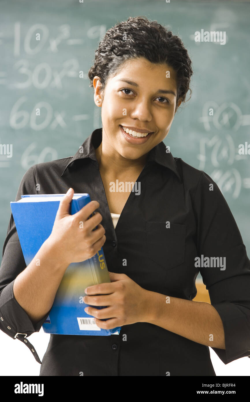 Weibliche Lehrer stehen vor einer Tafel Stockfoto