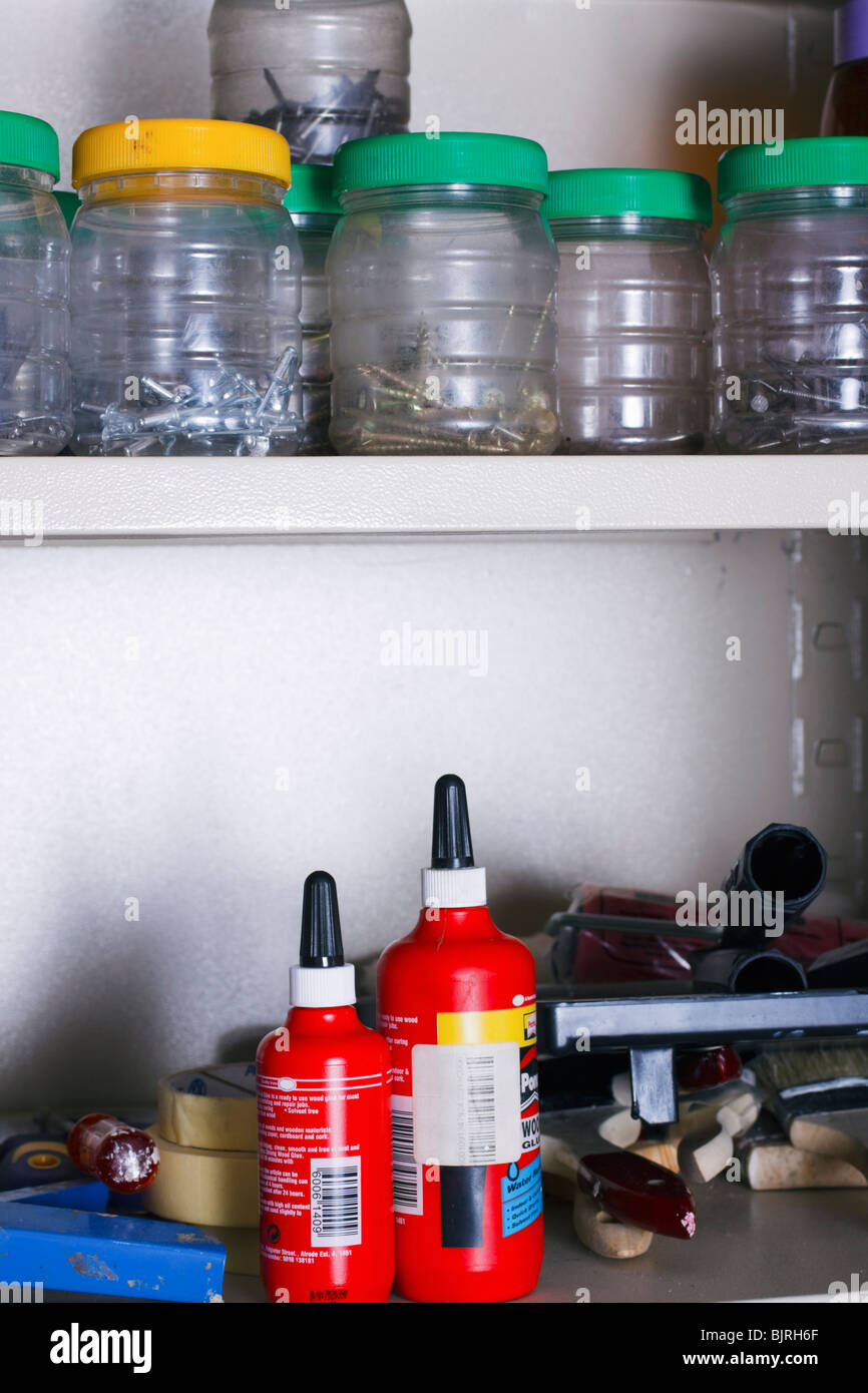 Werkzeuge, Schrauben und Hardware in den Regalen der einen Schrank in eine Heimat-Werkstatt. Stockfoto