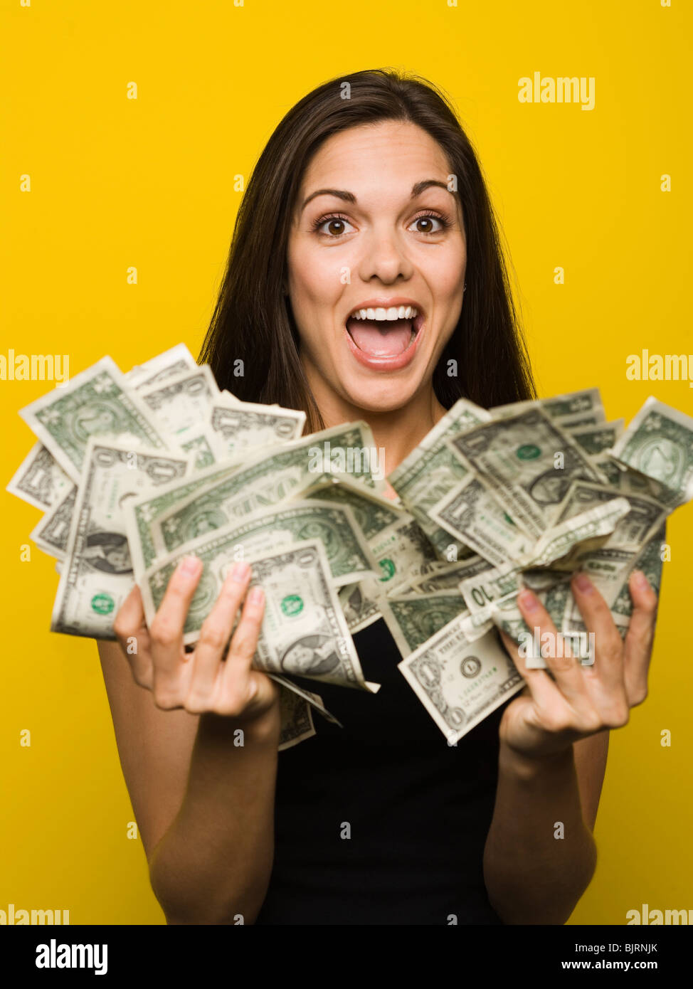 Glückliche Frau hält US-Dollarnoten Stockfoto