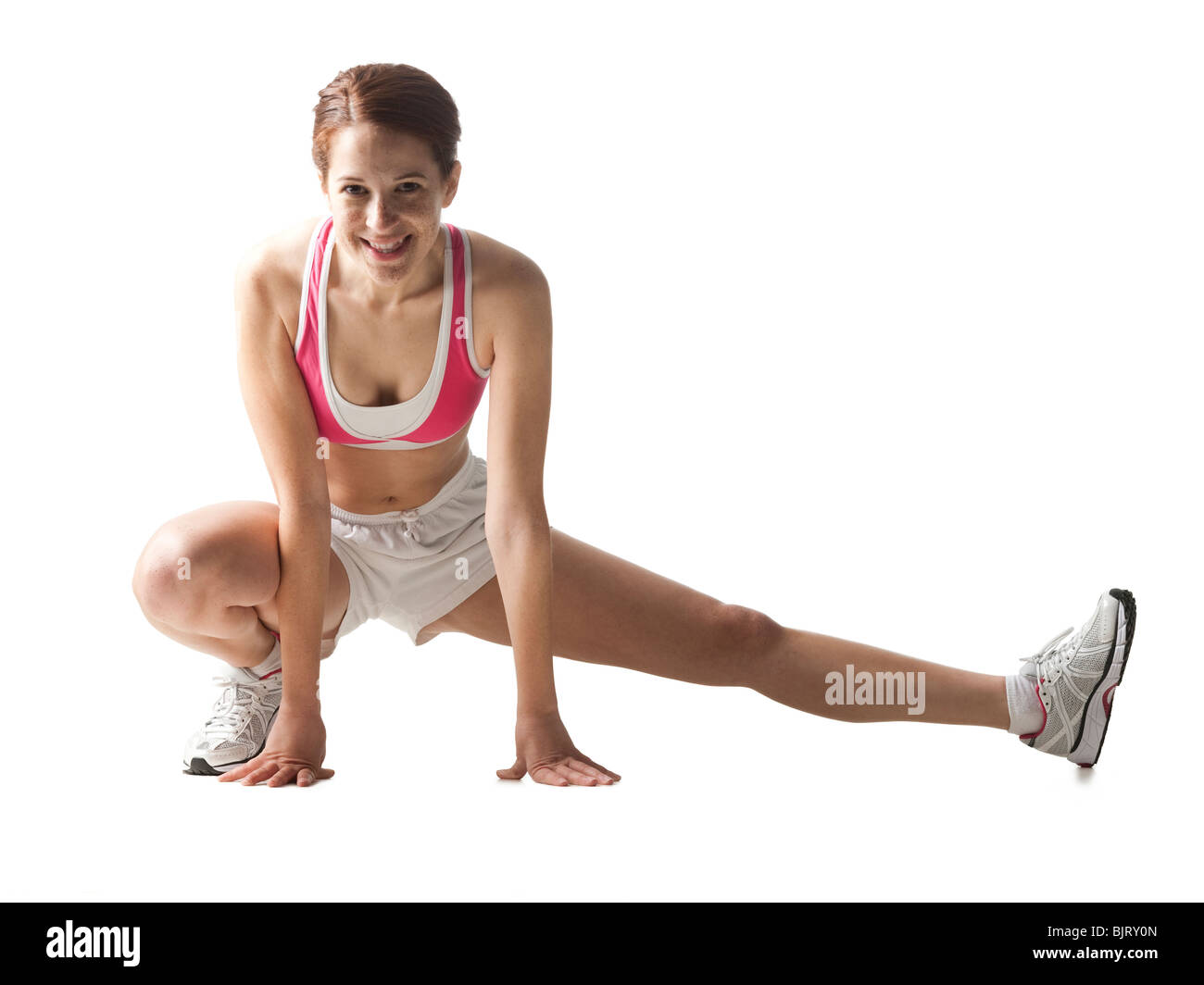 Junge Frau, dehnen, Studioaufnahme Stockfoto