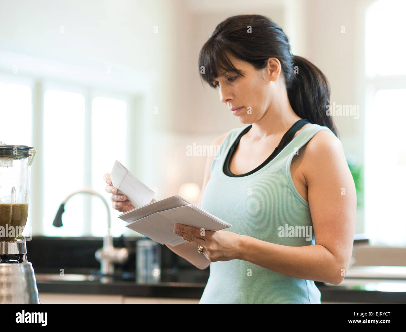 USA, Utah, Alpine, Mitte Erwachsene Frau mit Buchstaben in Küche Stockfoto