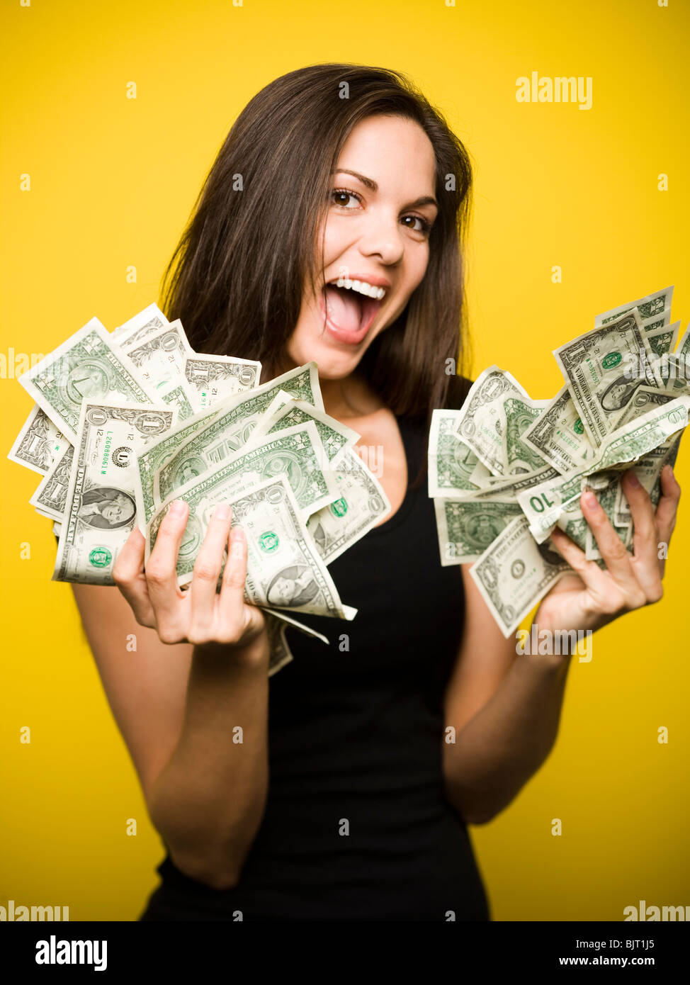 Glückliche Frau hält US-Dollarnoten Stockfoto