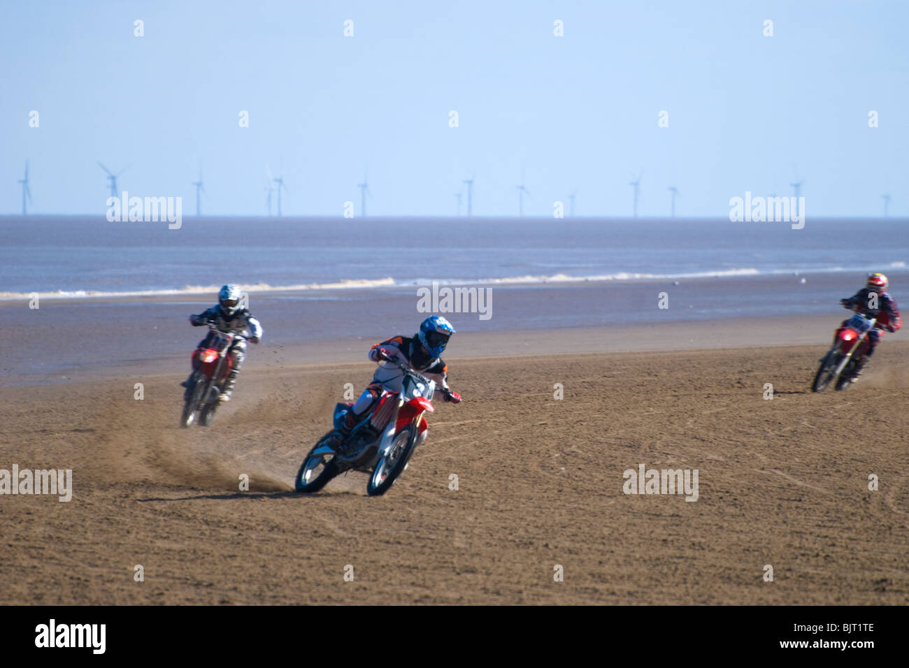 Motorrad-Sand Rennen am Strand mit Windkraftanlagen im Hintergrund, am Meer, Mablethorpe, Lincolnshire, England, UK Stockfoto