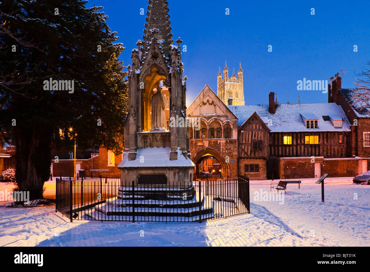 Die Dämmerung fällt auf Winterschnee am Bishop Hooper's Monument auf dem St. Mary's Square neben der Gloucester Cathedral UK Stockfoto
