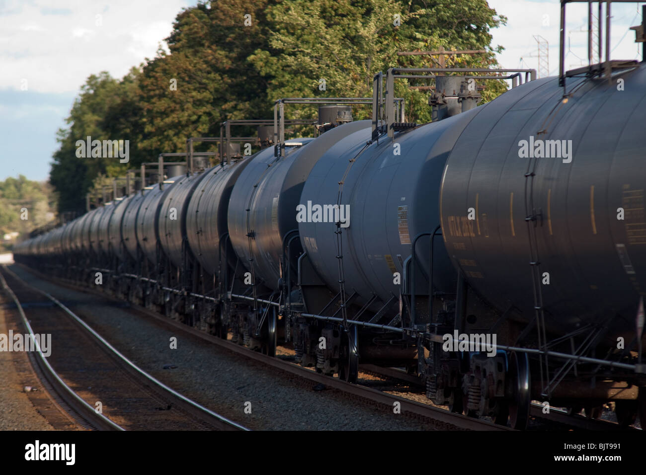 Ein Ganzzug von Ethanol Kesselwagen mit Bäumen Stockfoto