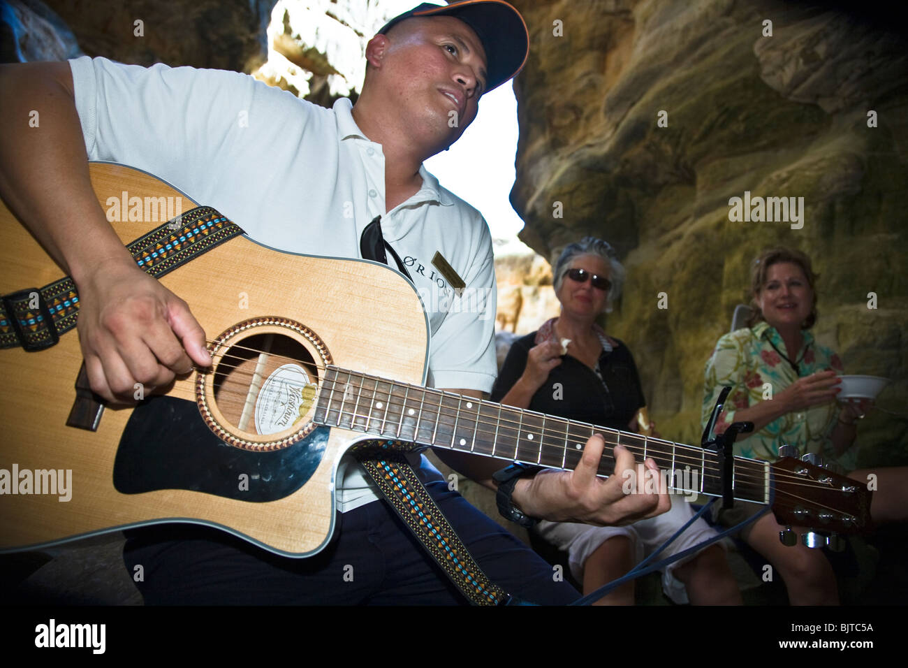 Crew-Mitglieder von Expedition Kreuzer Orion bieten Musik und Food-Service bei einem Besuch in Alladins Höhle auf Insel Bigge Stockfoto