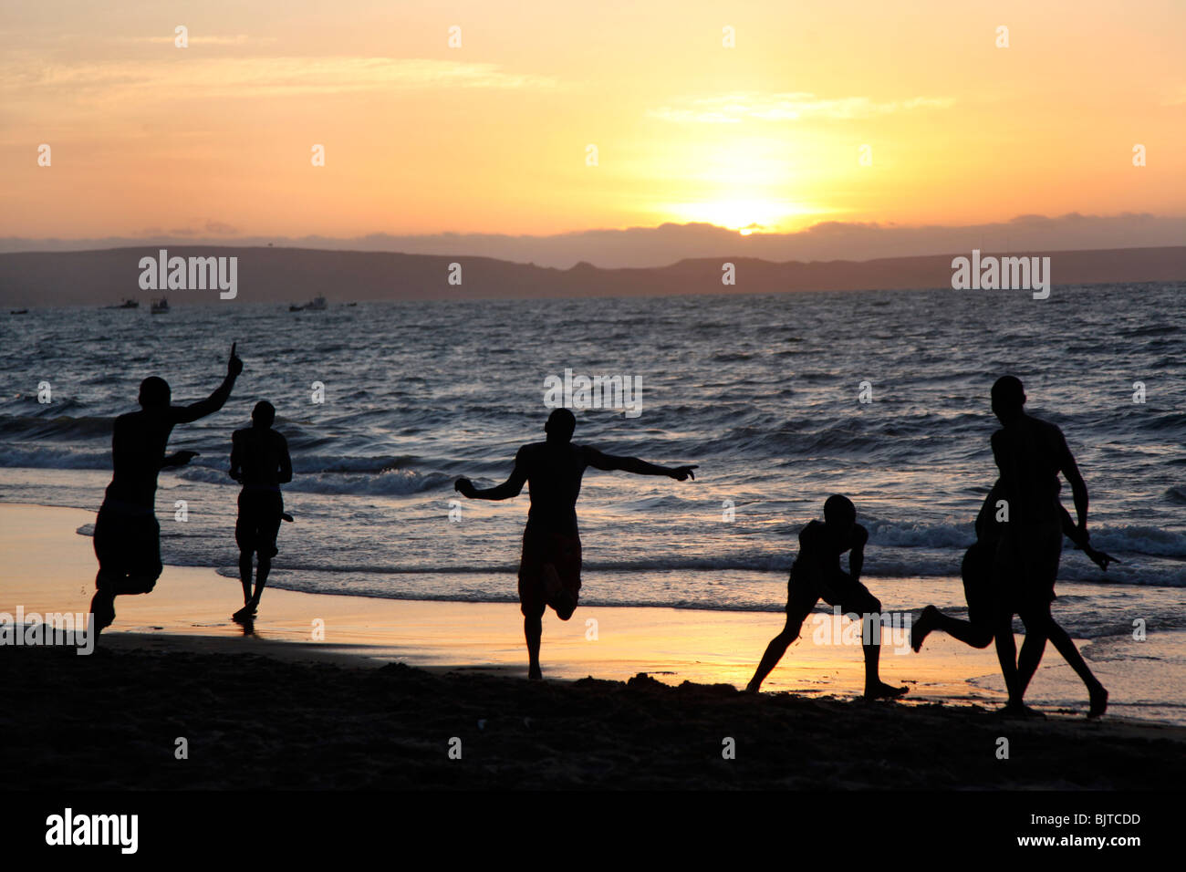 Freunde, Fußball am Strand spielen, wenn die Sonne untergeht. Stadtstrand Benguela, Angola. Africa © Zute Lightfoot Stockfoto
