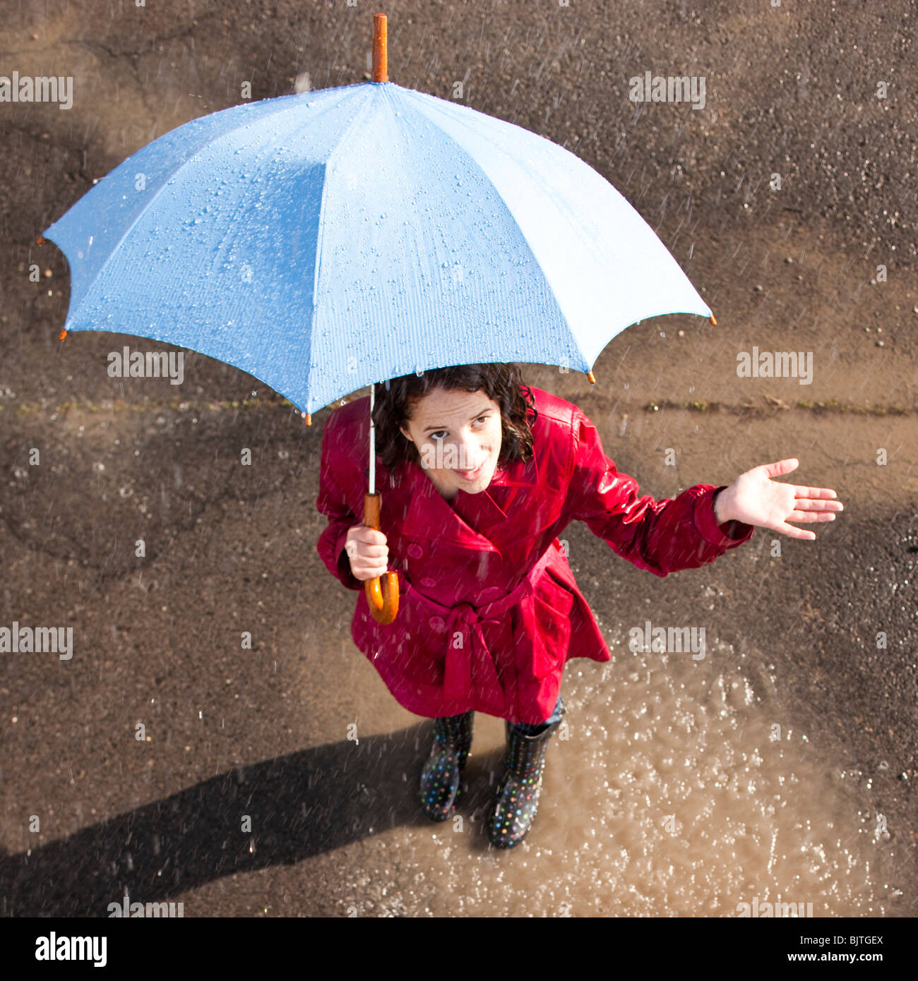 Junge Frau im Regen mit Regenschirm Stockfoto