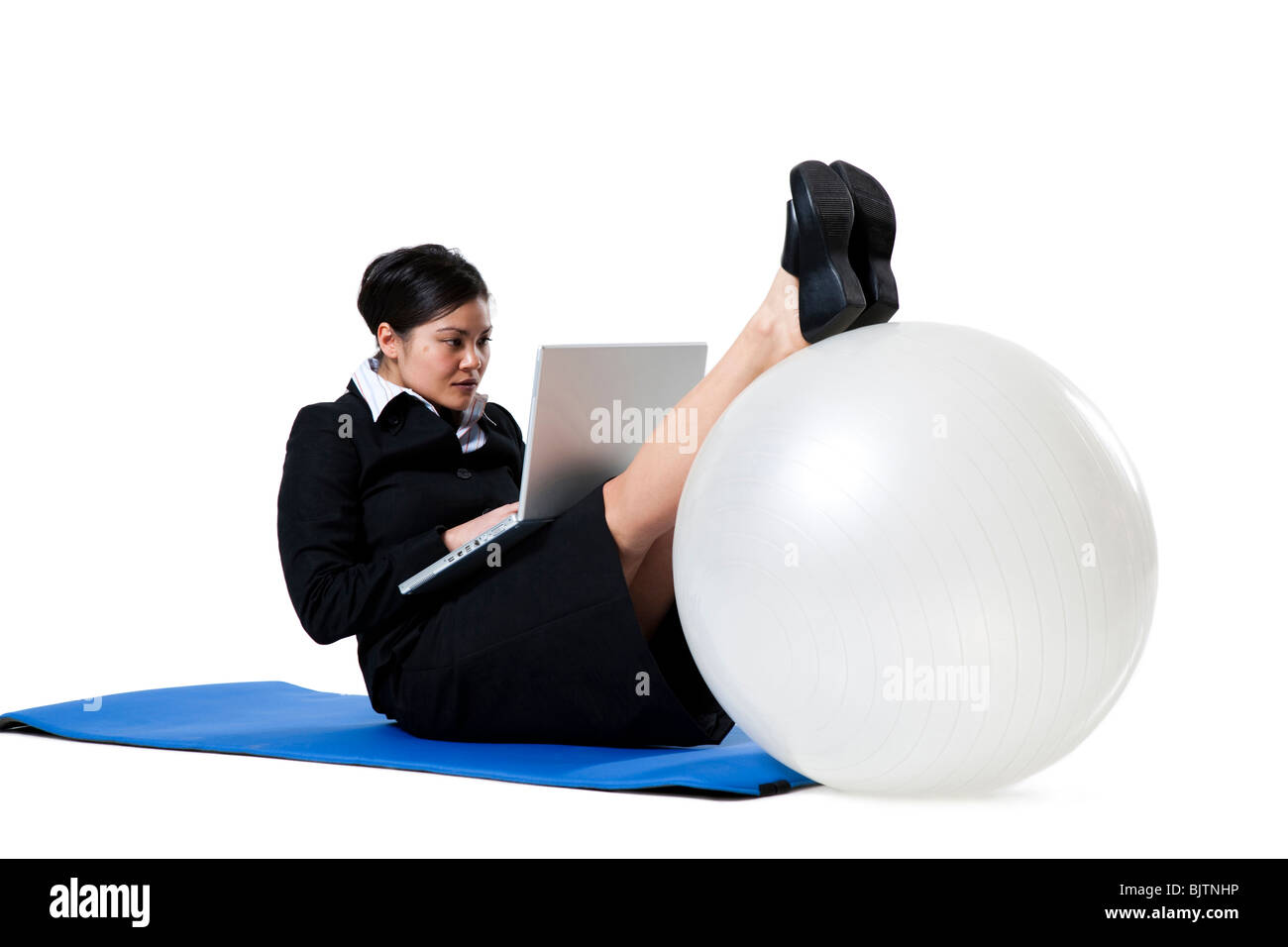 Frau beim Yoga mit laptop Stockfoto