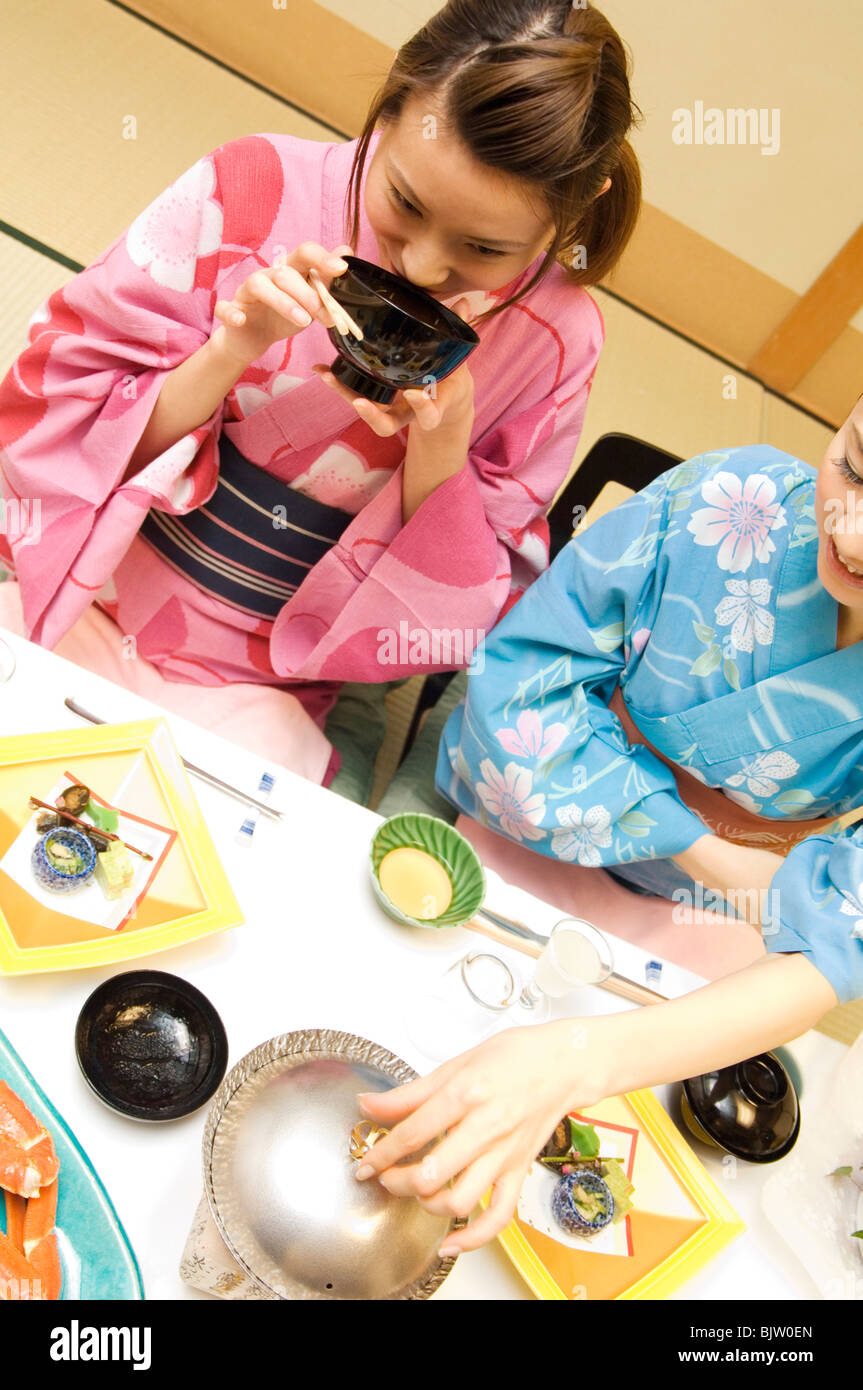 Frau gekleidet in einer Yukata und trinken Miso Suppe Stockfoto