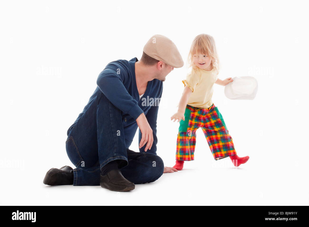 Junge mit langen blonden Haaren, die Spaß mit seinem Vater - isoliert auf weiss Stockfoto