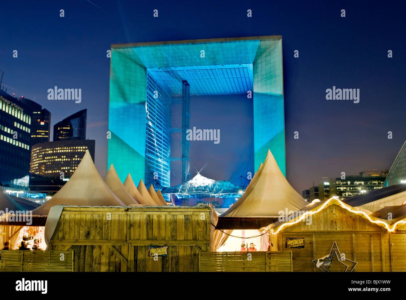 Paris, Frankreich, Weihnachtsmarkt / Marche au Noel / im Geschäftszentrum La Défense, beleuchtet in der Nacht mit dem Grand Arch Gebäude, (Kredit Architekt: Johan Otto von Spreckelsen) Stahlbetonkonstruktion Stockfoto