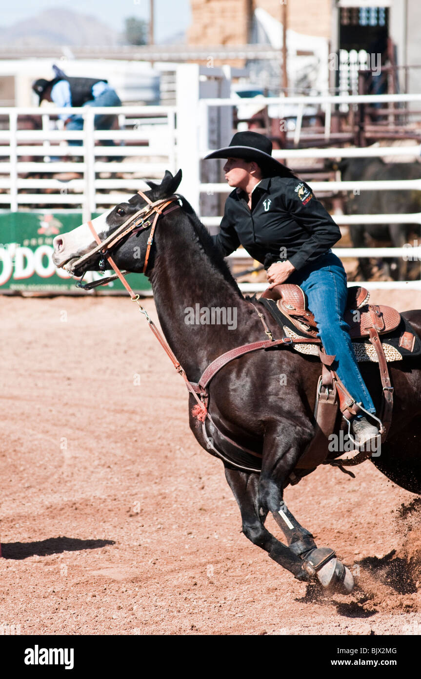 eine Cowgirl konkurriert in das Faßlaufen Ereignis bei einem rodeo Stockfoto