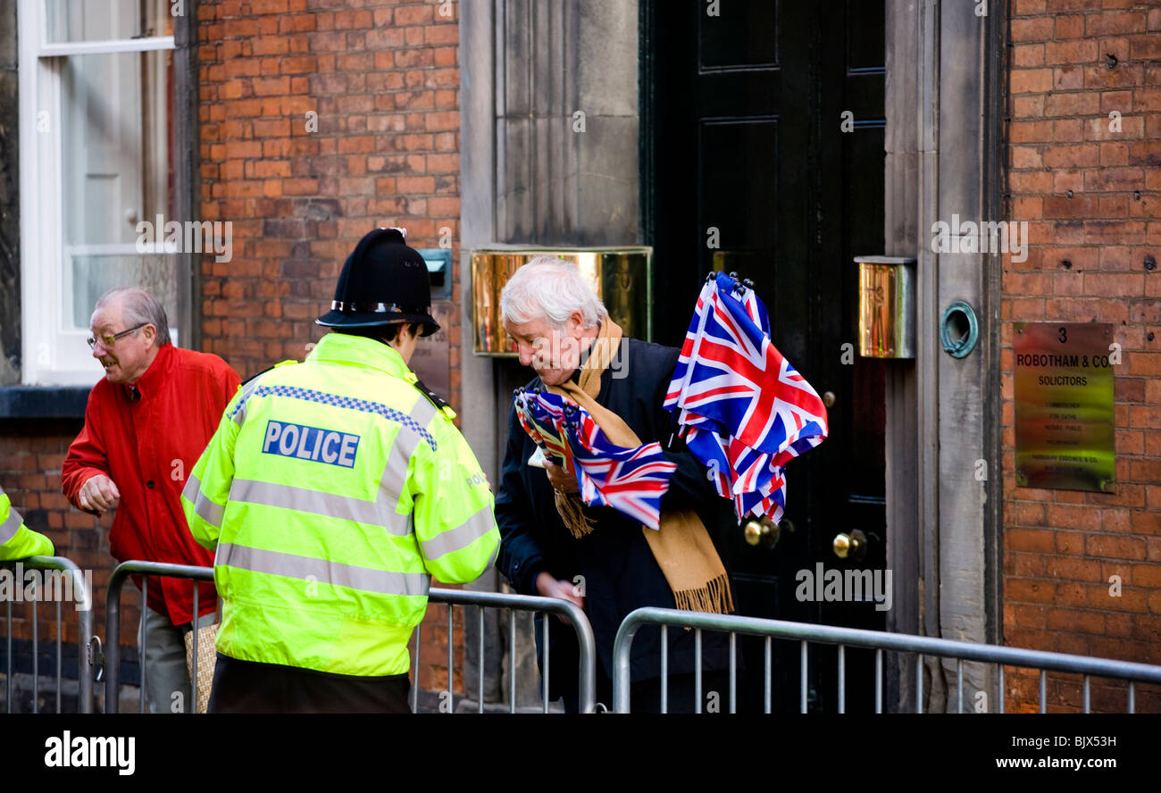 Eine UK-Polizist plaudert mit einem Gentleman Flagge Verkäufer bei einer Veranstaltung in Derby, wo die Königin ist, zu besuchen. Stockfoto