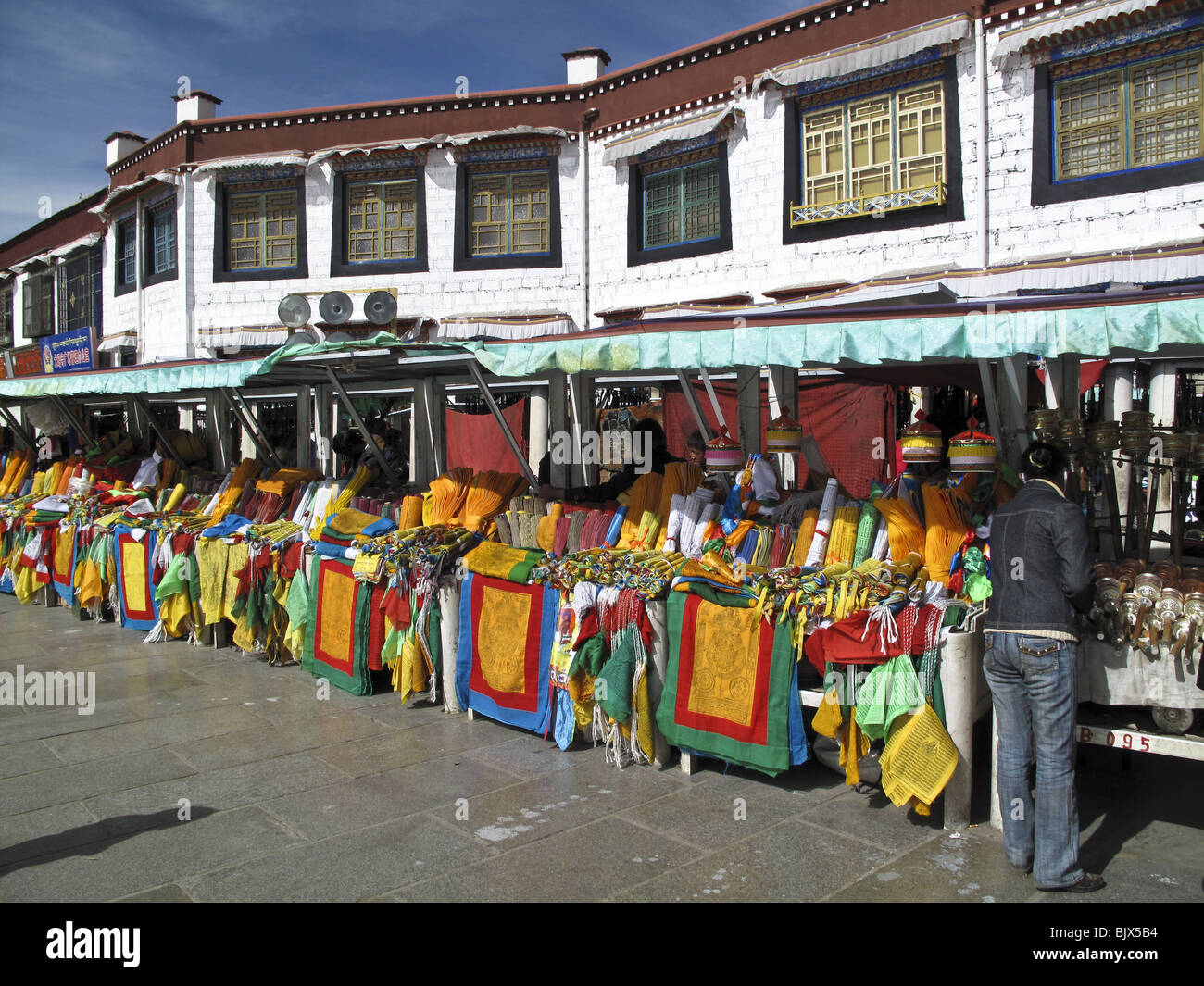 Anbieter verkaufen bunte buddhistische Gebetsfahnen in Ständen entlang Barkor-Platz in Lhasa, Tibet Stockfoto