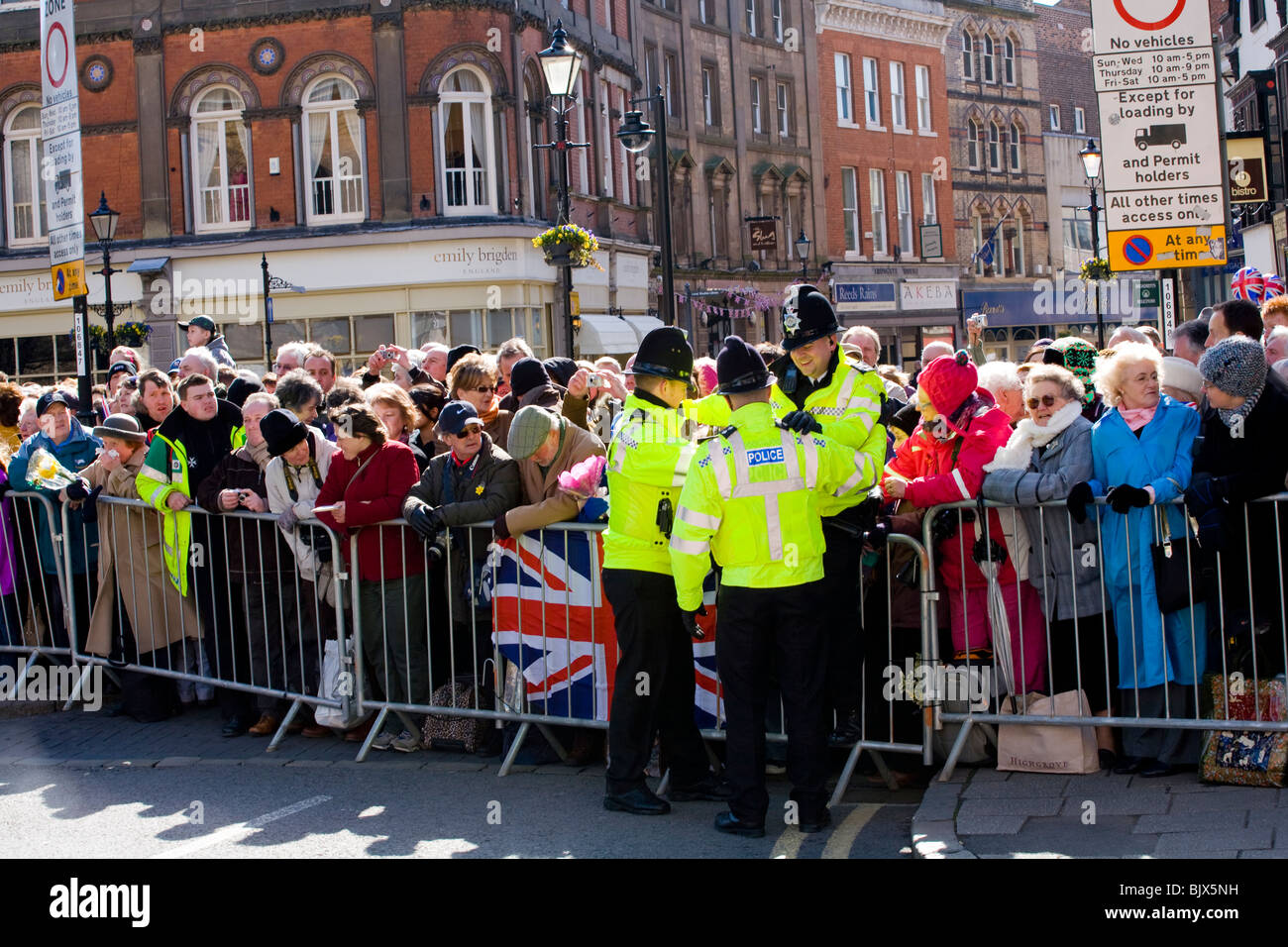 Polizisten helfen einen anderen Offizier hinter die Menschenmenge Barriere bei der Gründonnerstag-Zeremonie in Derby Stadtzentrum entfernt. Stockfoto