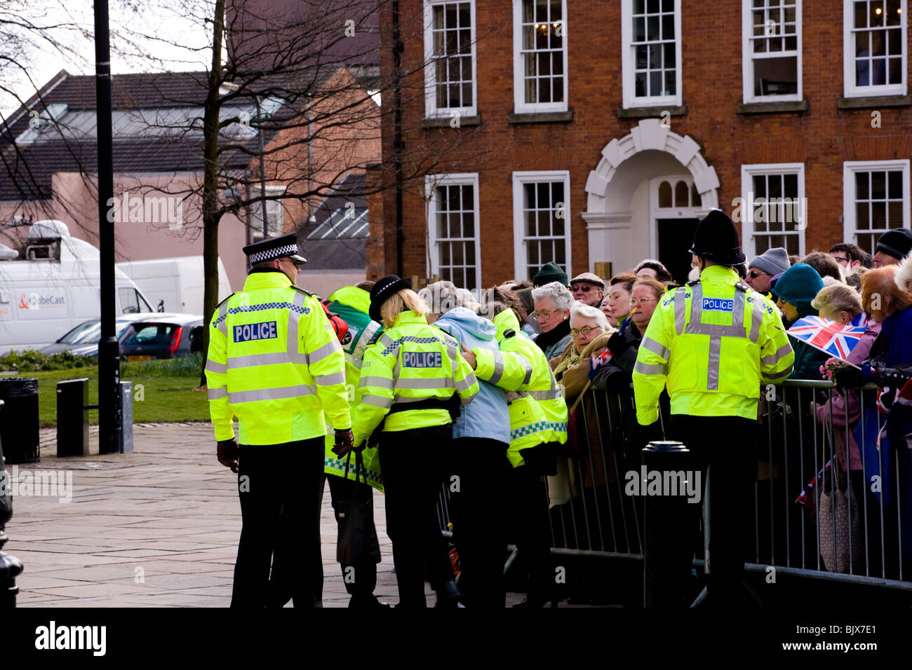 Polizei helfen, eine ältere Dame hinter der Menge Barriere im Derby am Gründonnerstag feiern und nehmen sie, sich hinzusetzen. Stockfoto