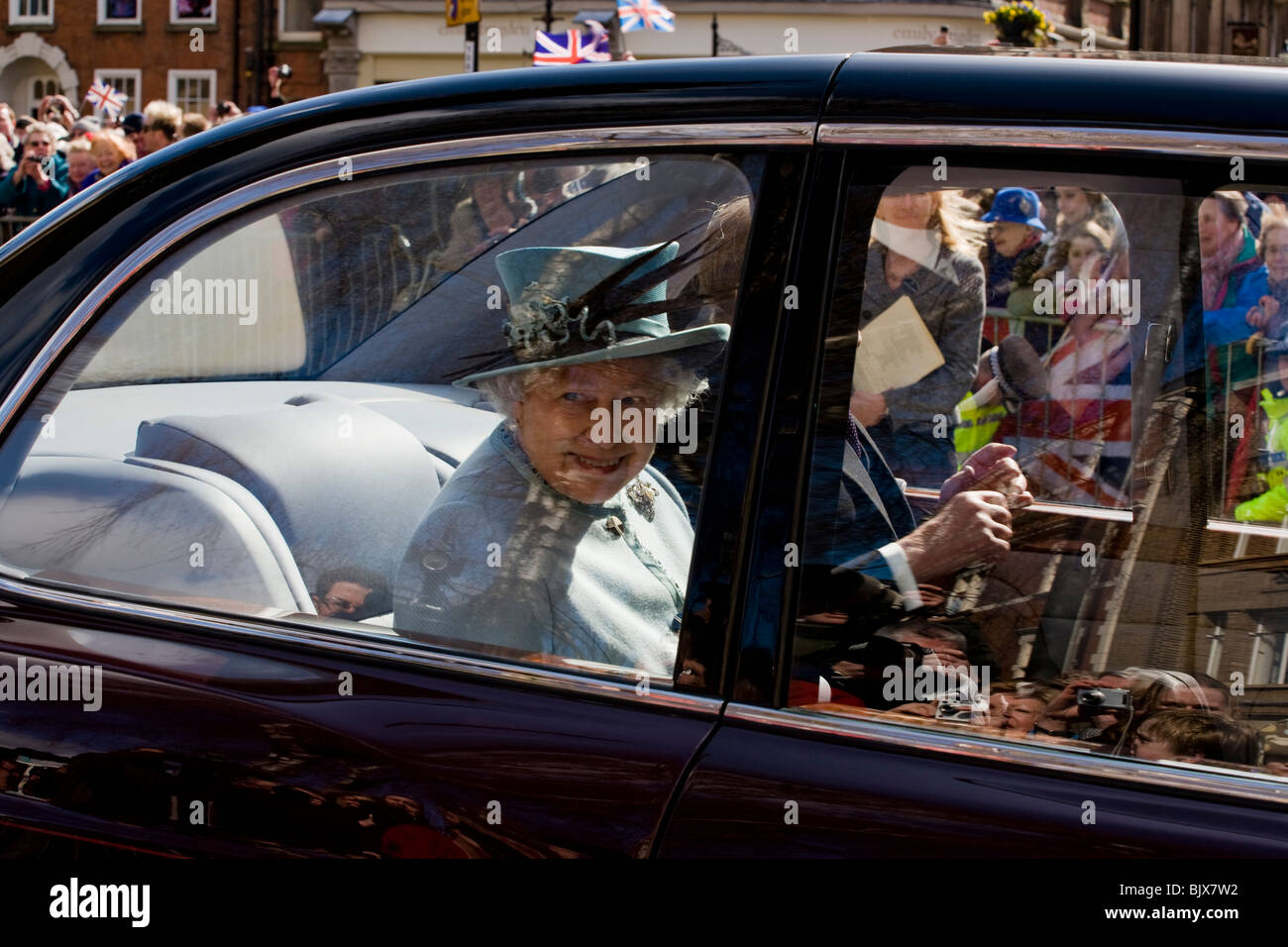 Ihre Majestät Königin Elizabeth II setzte auf der Rückseite ihrer Bentley State Limousine sich bei einem Besuch in Derby Maundy Geld geben Stockfoto