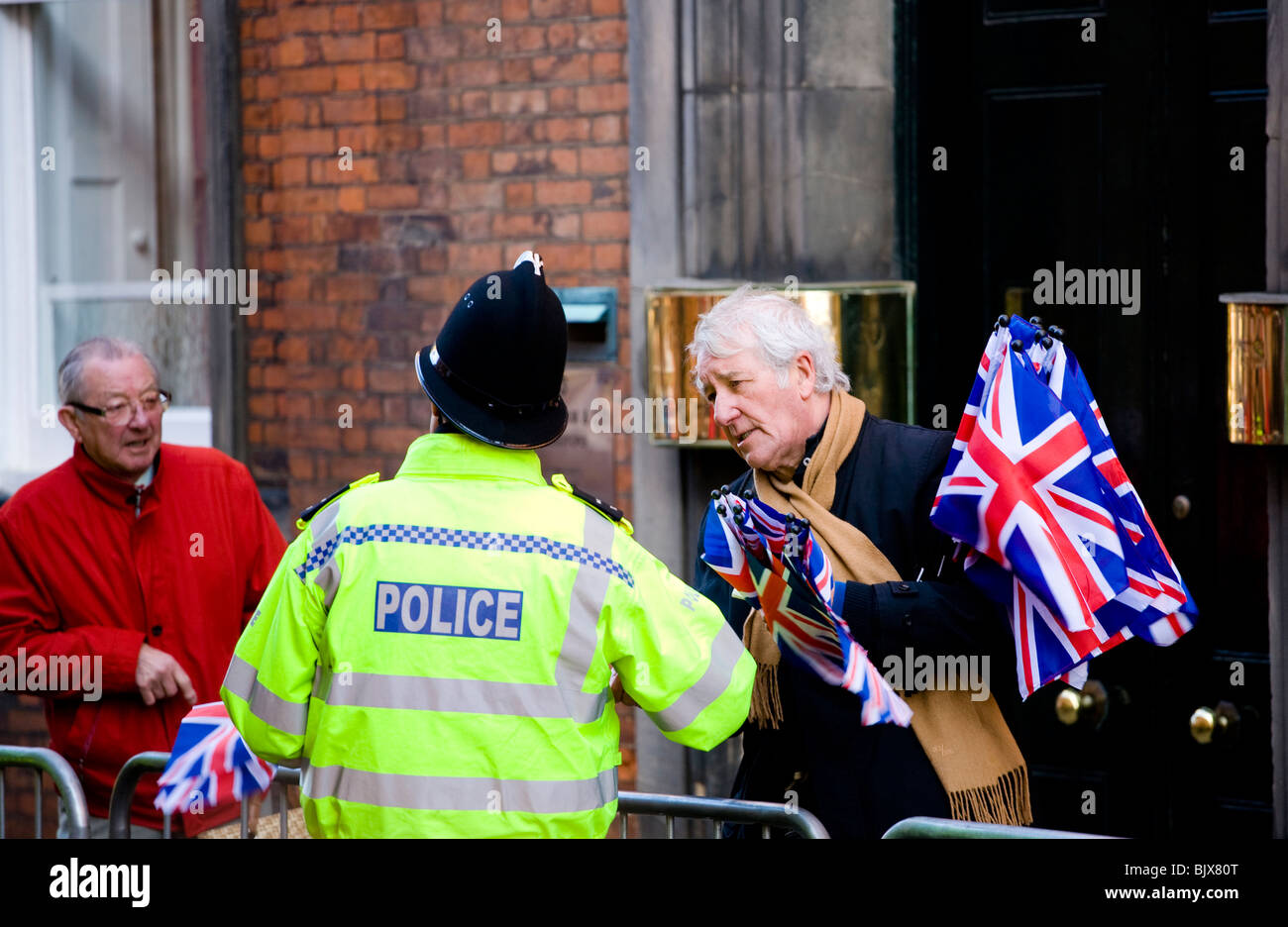 Eine UK-Polizist plaudert mit einem Gentleman Flagge Verkäufer bei einer Veranstaltung in Derby, wo die Königin ist, zu besuchen. Stockfoto