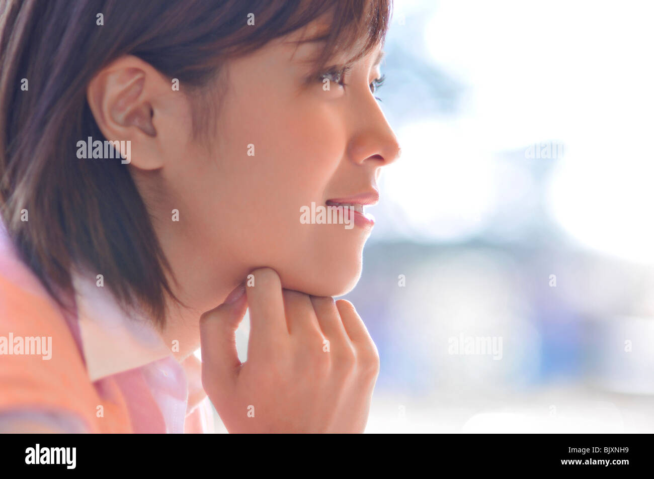 Porträt der jungen Frau mit der Hand am Kinn Stockfoto