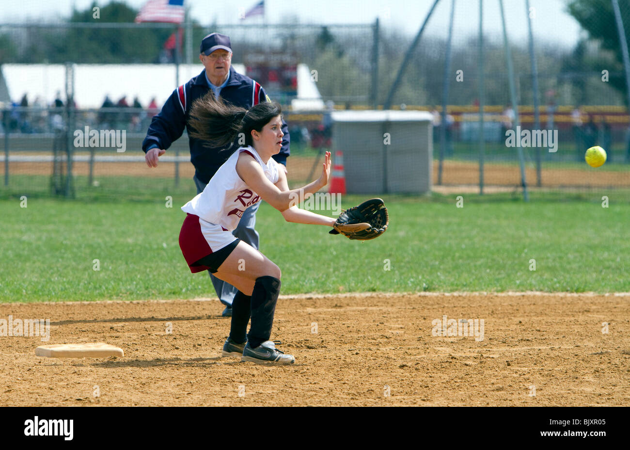 Mädchen-High School-Softball-Spiel. Ein Mädchen, das den Ball fängt. Stockfoto