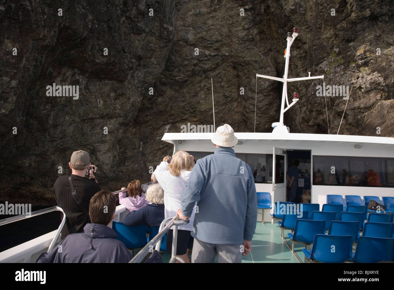 Bay Islands Nordinsel Neuseelands. Touristen-Gruppe auf Kreuzfahrt in der Nähe von Klippe Piercy "Hole in the Rock" Insel Stockfoto